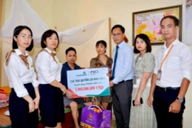 Đại diện Vietcombank Hải Dương và đại diện FWD Việt Nam thăm hỏi, tặng quà và trao biển tượng trưng chi trả quyền lợi bảo hiểm cho anh Phùng Văn Lực. (Ảnh: Vietnam+)