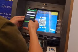 Khách hàng trải nghiệm dịch vụ rút tiền VietQRCash. (Ảnh: PV/Vietnam+)