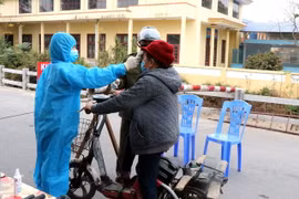 Lực lượng chức năng đo thân nhiệt tại chốt kiểm dịch thôn Nhiêu Đậu, xã Lâm Thao, huyện Lương Tài. (Ảnh: Đinh Văn Nhiều/TXVN)