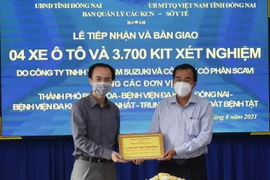 Doanh nghiệp trao tượng trưng bộ kit test nhanh COVID cho tỉnh Đồng Nai. (Ảnh: Công Phong/TTXVN)