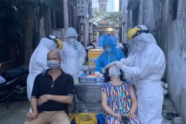 Lực lượng y tế lấy mẫu xét nghiệm những người liên quan đến các ca dương tính ở phường Việt Hưng, quận Long Biên, Hà Nội. (Ảnh: Văn Cảnh/TTXVN)