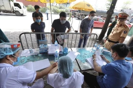 Lực lượng chức năng làm việc tại chốt Quốc lộ 5, huyện Gia Lâm. (Ảnh: Minh Quyết/TTXVN)