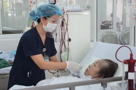 Chị Trần Thị Hoa, Điều dưỡng Trưởng, Khoa Thận nhân tạo-Lọc máu, Bệnh viện C Đà Nẵng đang chăm sóc bệnh nhân. (Ảnh: Văn Dũng/TTXVN)