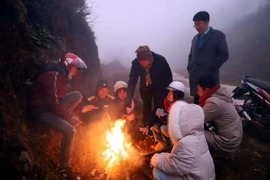 Du khách và người dân đốt lửa sưởi ấm ở núi. (Ảnh: TTXVN phát)
