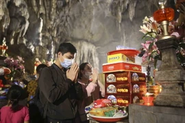 Du khách lễ Phật tại động Hương Tích đều tuân thủ việc đeo khẩu trang phòng dịch. (Ảnh: Tuấn Đức/TTXVN)