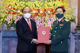 Chủ tịch nước Nguyễn Xuân Phúc tặng chân dung Chủ tịch Hồ Chí Minh cho Thượng tướng Nguyễn Tân Cương. (Ảnh: Thống Nhất/TTXVN)