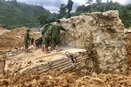 Lực lượng công binh phá khối bêtông cốt thép lớn tại vị trí sạt lở vui lấp các công nhân. (Ảnh: TTXVN phát)