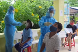 Người dân đến nhận tiền hỗ trợ tại xã Bình Kiến được test nhanh SARS-CoV-2. (Ảnh: Xuân Triệu/TTXVN)