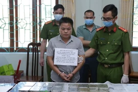 Đối tượng Sùng A Hồ, sinh năm 1991, trú tại bản Lao Tỷ Phùng, xã Nùng Nàng, huyện Tam Đường (Lai Châu) cùng tang vật vụ án. (Ảnh: Quý Trung/TTXVN)