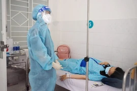 Bác sỹ Bệnh viện Hùng Vương theo dõi sức khỏe cho thai phụ mắc COVID-19. (Ảnh: TTXVN phát)