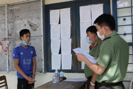 Bị can Trương Chí Tài nghe Công an đọc lệnh bắt tạm giam. (Ảnh: TTXVN phát)