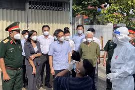 Phó Thủ tướng Vũ Đức Đam kiểm tra công tác test nhanh COVID-19 và khuyến khích người dân tự thử xét nghiệm. (Ảnh: Huyền Trang/TTXVN)
