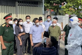 Phó Thủ tướng Vũ Đức Đam kiểm tra công tác test nhanh COVID-19 và khuyến khích người dân tự thử xét nghiệm. (Ảnh: Huyền Trang/TTXVN)
