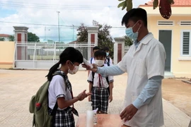 Học sinh được đo thân nhiệt, rửa tay sát khuẩn trước khi vào lớp. (Nguồn: baolamdong)