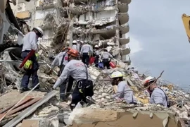 Lực lượng cứu hộ tìm kiếm nạn nhân dưới đống đổ nát của tòa nhà bị sập ở hạt Miami-Dade, thành phố Surfside, bang Florida, Mỹ ngày 25/6 vừa qua. (Ảnh: THX/TTXVN)