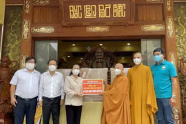 Hòa thượng Thích Thiện Nhơn trao bảng tượng trưng số máy thở đa năng cho bà Nguyễn Thị Lệ. (Ảnh: TTXVN phát)