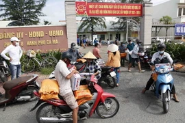 Người dân phấn khởi mang lương thực, thực phẩm về nhà sử dụng trong thời gian thục hiện giãn cách xã hội. (Ảnh: Kim Há/TTXVN)