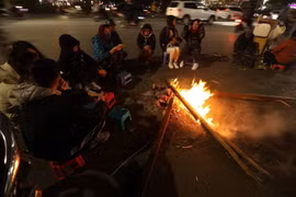 Nhiều người quây quần bên đống lửa để sưởi ấm. (Ảnh: Phan Tuấn Anh/TTXVN)