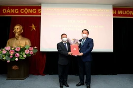 Ông Nguyễn Trọng Nghĩa, Bí thư Trung ương Đảng, Trưởng Ban Tuyên giáo Trung ương trao Quyết định của Ban Bí thư cho ông Đỗ Hồng Quân. (Ảnh: TTXVN phát)