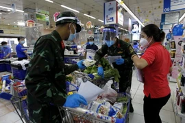 Nhiều chiến sỹ nhờ trợ giúp thông tin, hàng hóa từ các nhân viên siêu thị để "đi chợ giúp dân" đúng và đầy đủ theo nhu cầu." (Ảnh: Thanh Vũ/TTXVN)