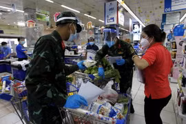 Nhiều chiến sỹ nhờ trợ giúp thông tin, hàng hóa từ các nhân viên siêu thị để "đi chợ giúp dân" đúng và đầy đủ theo nhu cầu." (Ảnh: Thanh Vũ/TTXVN)