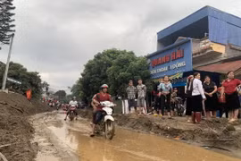 Bùn đất theo lũ trôi về tràn ngập trên Quốc lộ 279. (Ảnh Hồng Ninh/TTXVN)