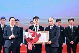 Thủ tướng Nguyễn Xuân Phúc, Chủ tịch Hội đồng Thi đua-Khen thưởng Trung ương trao tặng Huân chương lao động hạng Nhất cho em Bùi Hồng Đức, học sinh lớp 12, Trường THPT chuyên Khoa học Tự nhiên, trường Đại học Tự nhiên, Đại học Quốc gia Hà Nội. (Ảnh: Thống