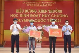 Phó Chủ tịch UBND tỉnh Vĩnh Phúc Vũ Việt Văn trao thưởng cho 2 học sinh đoạt huy chương Olympic quốc tế năm 2021. (Ảnh: Nguyễn Thảo/TTXVN)