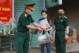 Lực lượng bộ đội thuộc Sư đoàn 302-Quân khu 7 gửi tặng nhu yếu phẩm cho người dân đang thực hiện cách ly tại nhà ở phường Xuân Thanh, Cẩm Mỹ, Đồng Nai. (Ảnh: Lê Xuân/TTXVN)
