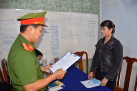Cơ quan Cảnh sát điều tra Công an tỉnh tống đạt quyết định khởi tố bị can Nguyễn Thị Thanh Thúy. (Ảnh Công Trí/TTXVN)