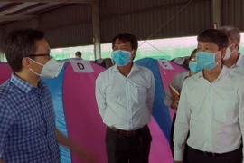 Phó Thủ tướng Vũ Đức Đam thăm, kiểm tra mô hình “3 tại chỗ” tại Công ty TNHH Yazaki EDS Việt Nam, thành phố Dĩ An. (Ảnh: TTXVN phát)