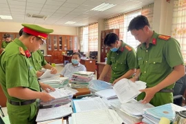 Lực lượng công an khám xét nơi làm việc của các đối tượng, thu giữ nhiều tang vật liên quan đến vụ án. (Ảnh: Công an tỉnh An Giang cung cấp/TTXVN phát)