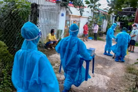 Đội tình nguyện đi lấy mẫu xét nghiệm cho người dân phường An Bình, quận Binh Kiều ngày 17/9. (Ảnh: Thanh Liêm/TTXVN)