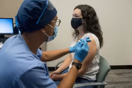 Nhân viên y tế tiêm thử nghiệm vaccine ngừa COVID-19 của Moderna. (Ảnh: AFP/TTXVN)