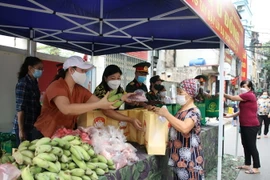 Trao quà hỗ trợ cho người dân tại Chợ 0 đồng. (Ảnh: TTXVN phát)