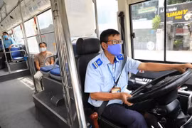 Lái xe buýt thực hiện nghiêm việc đeo khẩu trang y tế khi đang làm việc. (Ảnh: Thành Đạt/TTXVN)