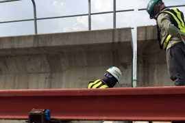 Hiện trường khắc phục sự cố gối cao su sử dụng cho dầm cầu cạn của gói thầu số 2 (CP2) bị mất ổn định rơi khỏi đá kê gối. (Ảnh: TTXVN phát)