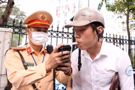 Cảnh sát Giao thông kiểm tra nồng độ cồn. (Ảnh: Phạm Kiên/TTXVN)