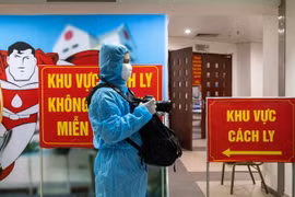 Phóng viên Minh Quyết, Ban Biên tập Ảnh TTXVN, tác nghiệp trong khu cách ly phòng COVID-19. (Ảnh: TTXVN)