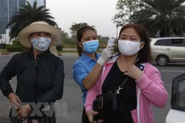Đo thân nhiệt. (Ảnh: Thanh Vũ/TTXVN)