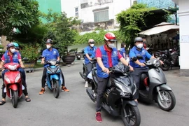 Các thành viên đội Shipper tình nguyện xuất phát về các phường-xã làm nhiệm vụ vận chuyển hàng hóa từ các Tổ an sinh đến người dân. (Ảnh: Xuân Khu/TTXVN)