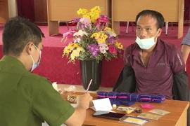 Đối tượng Lý A Đáp cũng tang vật tại cơ quan công an. (Ảnh: TTXVN phát)