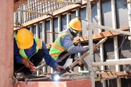 Công nhân nỗ lực thi công tại dự án hầm chui nút giao thông Nguyễn Văn Linh-Nguyễn Hữu Thọ trước khi có dịch COVID-19. (Ảnh: Tiến Lực/TTXVN)