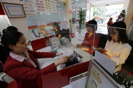 Hoạt động nghiệp vụ tại Ngân hàng thương mại Cổ phần nhà Thành phố Hồ Chí Minh (HD Bank) chi nhánh Hà Nội. (Ảnh: Trần Việt/TTXVN)
