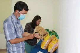 Khách hàng tìm hiểu thông tin sản phẩm gạo Mắt rồng. (Ảnh: Xuân Anh/TTXVN)