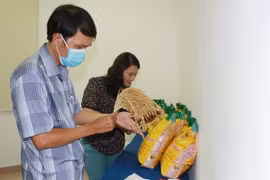 Khách hàng tìm hiểu thông tin sản phẩm gạo Mắt rồng. (Ảnh: Xuân Anh/TTXVN)