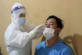 Công dân được test nhanh COVID-19 trước khi vào địa bàn Lai Châu. (Ảnh: Nguyễn Oanh/TTXVN)