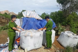 Lực lượng công an kiểm tra, xác minh số chất thải xuống khu vực bãi rác, thuộc Tiểu khu Vũ Yên, thị trấn Nông Cống, tỉnh Thanh Hóa. (Ảnh: Trịnh Duy Hưng/TTXVN)