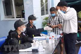 Lực lượng chức năng tại chốt kiểm soát trên Quốc lộ 51, đoạn giao với cao tốc Thành phố Hồ Chí Minh-Long Thành-Dầu Giây hướng dẫn người dân đi từ Thành phố Hồ Chí Minh về Đồng Nai khai báo y tế. (Ảnh: Lê Xuân/TTXVN)