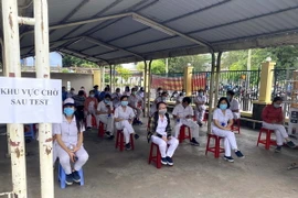 Công nhân Công ty TNHH Nagata Việt Nam tại Khu chế xuất Tân Thuận, quận 7 được lấy mẫu xét nghiệm COVID-19. (Ảnh: TTXVN phát)